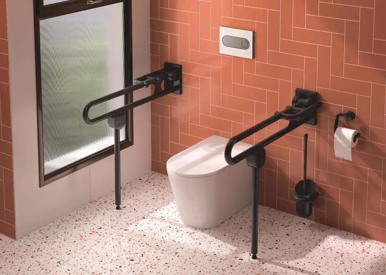 WC mit schwarzen Haltegriffen und orangefarbener Wand. WC avec barres noires et mur orange.